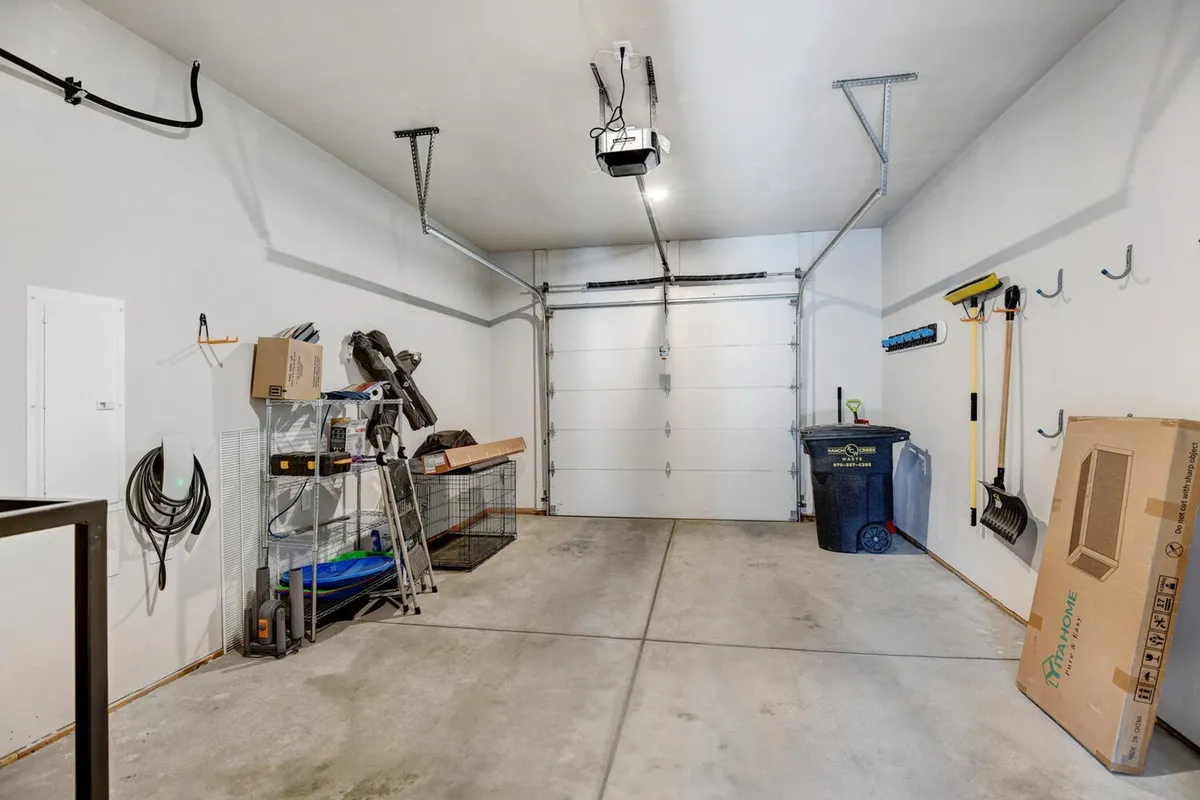A spacious, well-organized heated garage complete with storage shelves, tools, and bins, ideal for stowing outdoor gear and equipment after a day of adventure.
