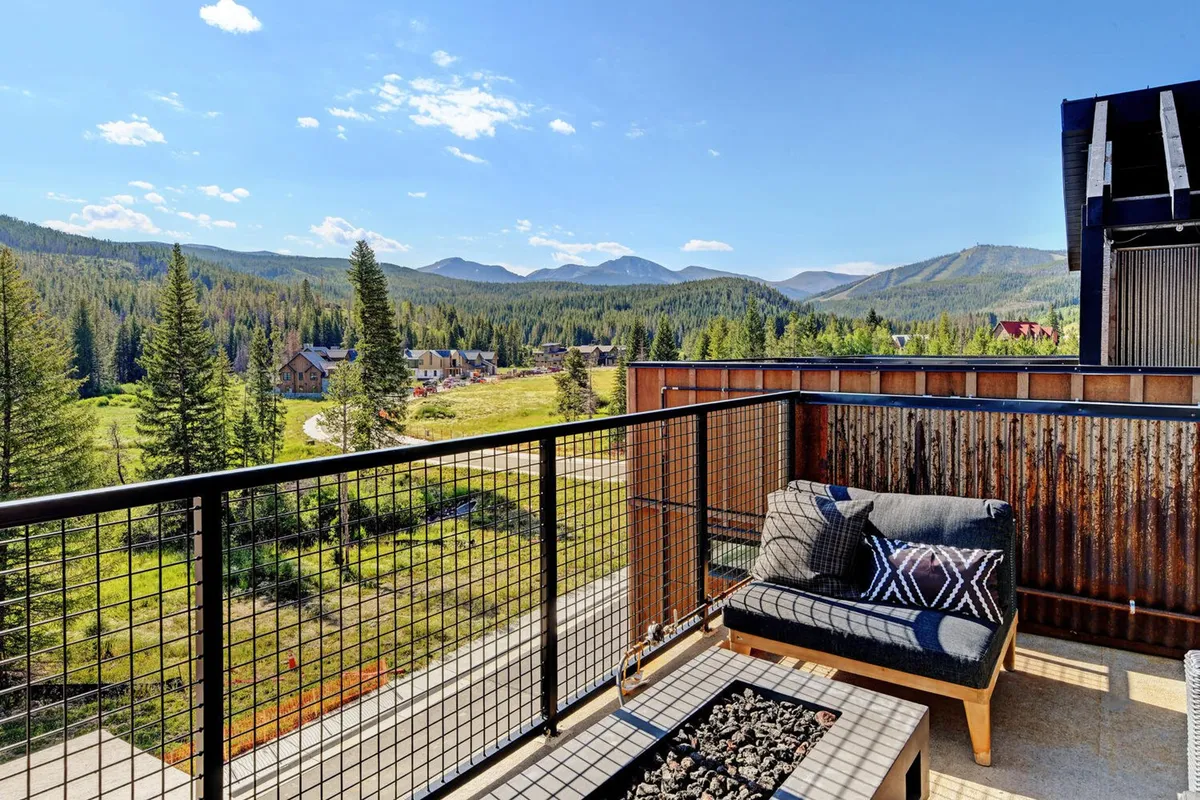 An outdoor seating area with comfortable chairs, a fire pit, and breathtaking mountain views. The tranquil scene is perfect for relaxing, socializing, and soaking in the natural beauty that defines Winter Park's appeal across seasons.